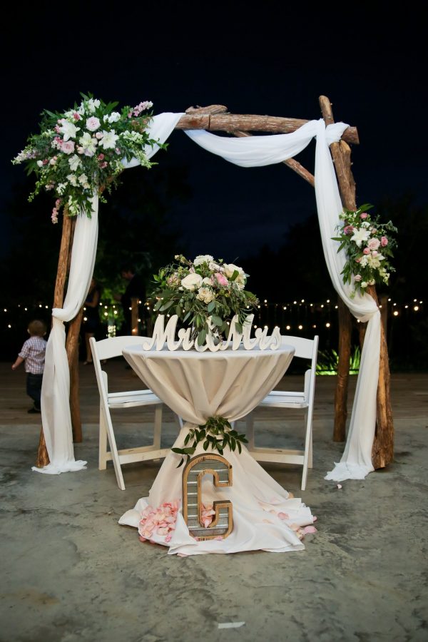 head table with wooden arbor